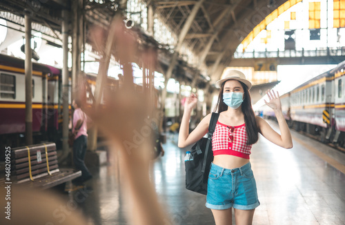 Woman traveler with bag  luggage  arrival   during traveling  travel  trip for woman concept  say hi  good bye to friend.trip in summer with face mask for protection by infection from Coronavirus.