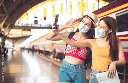 Woman traveler with bag, luggage, arrival during traveling, travel, trip for woman concept, say hi, good bye to friend.trip in summer with face mask for protection by infection from Coronavirus.