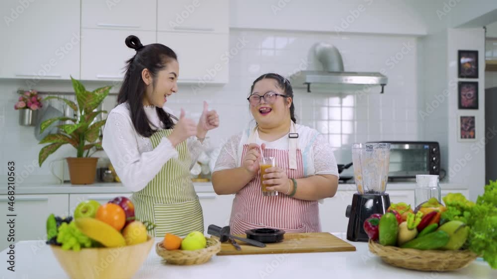 Down syndrome girl cooking with mom Smile.making fruit smoothies The concept is mental health, physical growth. Brain growth, learning, family love, intelligence, cooking Down syndrome girl cooking with mom Smile.making fruit smoothies The concept is mental health, physical growth. Brain growth, learning, family love, intelligence, cooking
