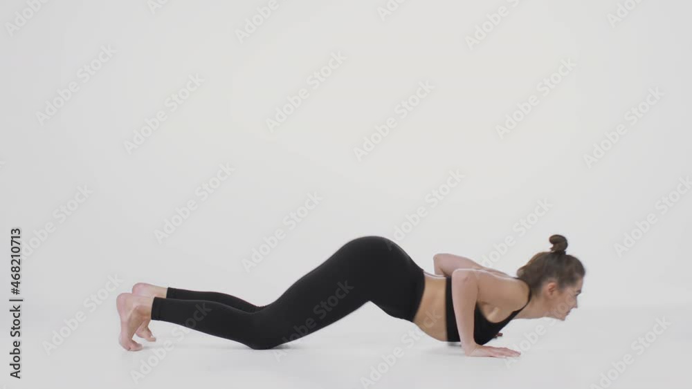 Cobra position. Side view shot of flexible woman performing back stretching exercise, practicing over white background Cobra position. Side view shot of flexible woman performing back stretching exercise, practicing over white background