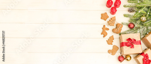Christmas and New Year card with a composition of gifts  Christmas tree decorations and gingerbread cookies on a white wooden background with copy space