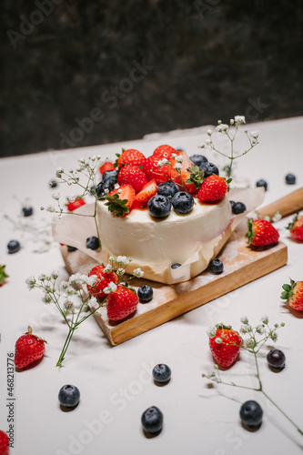 Confectionery on white background, strawberry blueberry cake