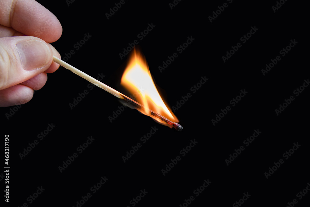 Human fingers holding burning match on black background. Human fingers holding burning match on black background.