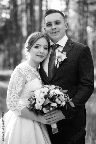 the bride and groom are walking in a pine forest