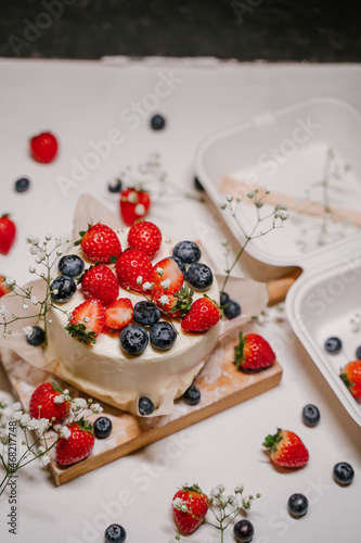 Beautiful strawberry cake decorated with blueberries on a white background