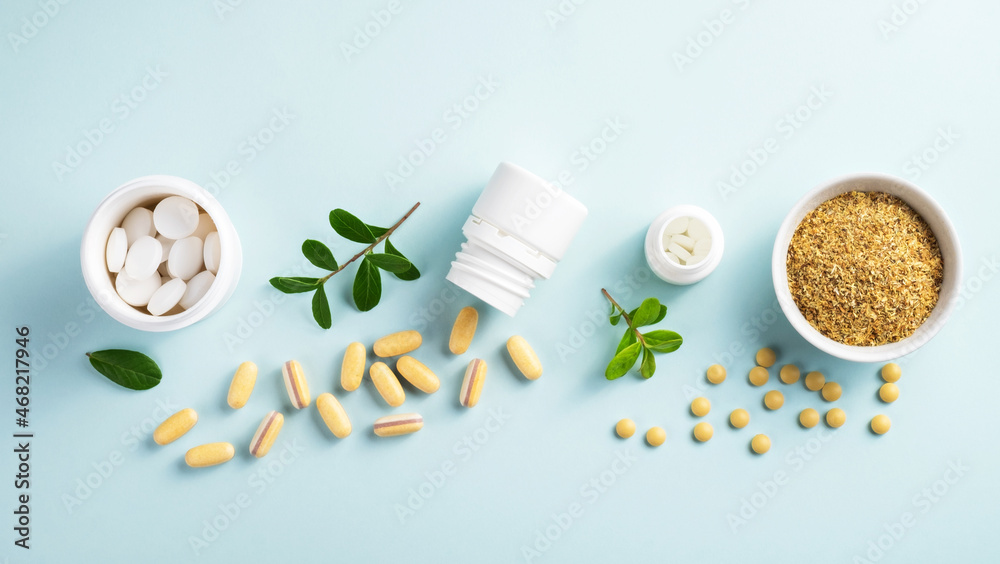 Vitamins and herbal supplements in jars with a green plant on a blue background..Biologically active additives. Dietary supplements.