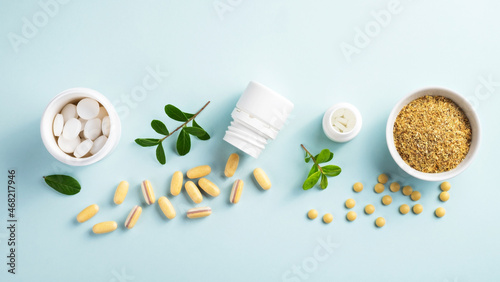 Vitamins and herbal supplements in jars with a green plant on a blue background..Biologically active additives. Dietary supplements.