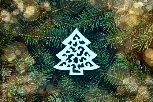 A Christmas concept made of fir branches with a white wooden herringbone in the center.anches with a star. photo