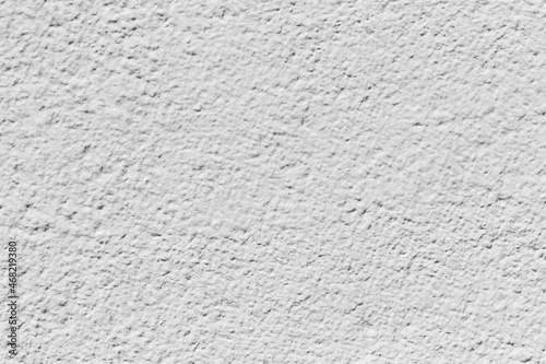Old concrete wall covered with pastel pale white paint.