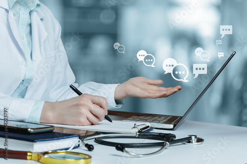 Doctor is in correspondence with patients on a laptop in the hospital. photo