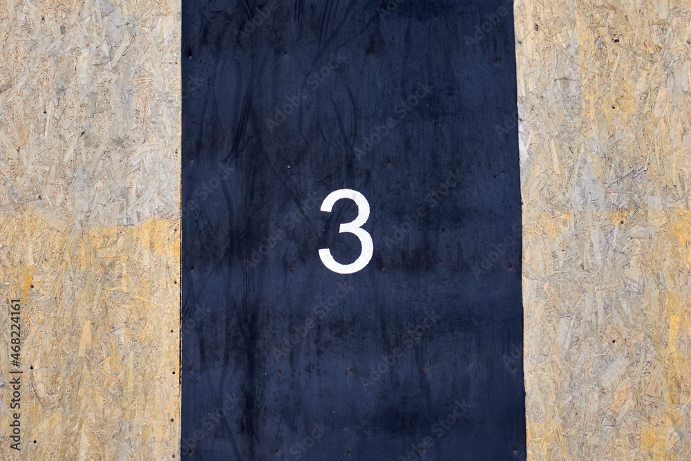 Number 3 painted with white paint on a black rubber surface Number 3 painted with white paint on a black rubber surface