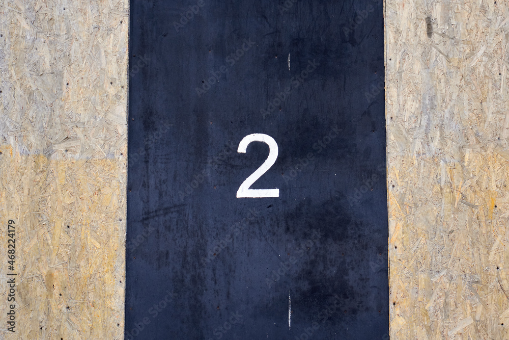 Number 2 painted with white paint on a black rubber surface Number 2 painted with white paint on a black rubber surface