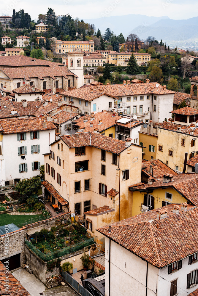 Roofs of ancient buildings against the backdrop of mountains. Bergamo, Italy