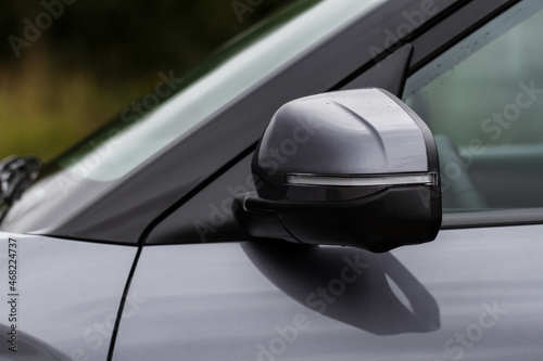 Close up front view of car side mirror. Front rear view mirror on the car window. Car exterior details.