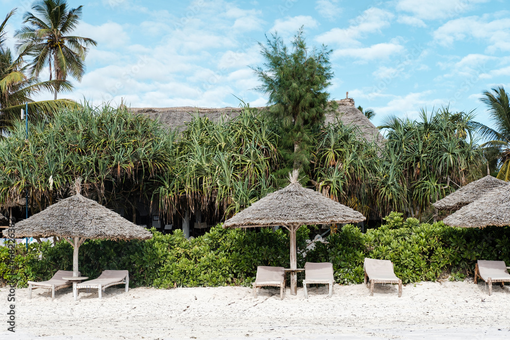 Huts and beach furniture along the Indian Ocean in Zanzibar, Tanzania 