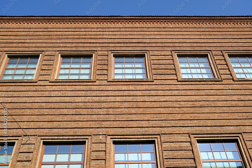 Brick wall of a museum.  Large windows on the brick facade of the Cremona violin museum.