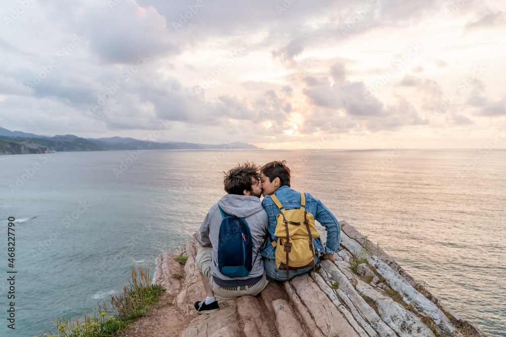 Horizontal view of young couple in love sightseeing in Zumaia cliffs. Horizontal panoramic view of young couple traveling in vasque country. People and travel destination in Spain