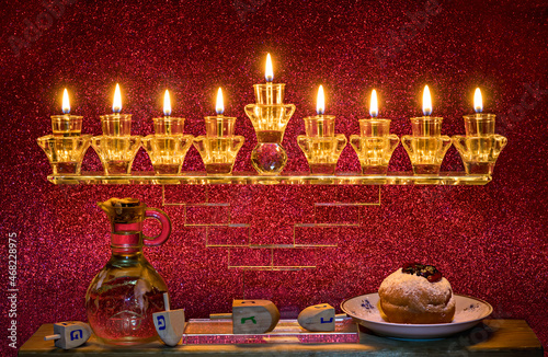 Image depicts Jewish holiday Hanukkah with menorah and burning candles, jar w...