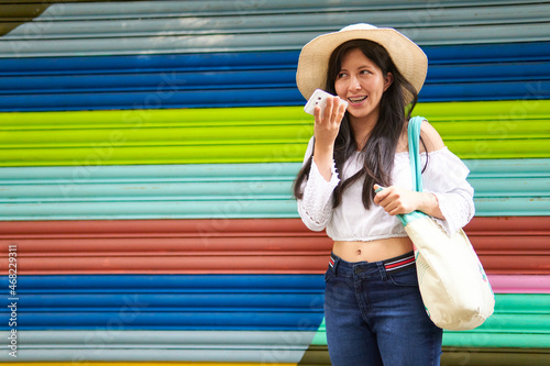 young woman sending an audio on a colorful background, copy space