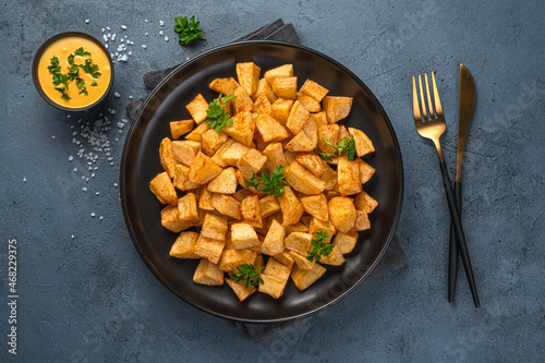 Patatas bravas is a traditional Spanish snack on a gray background.