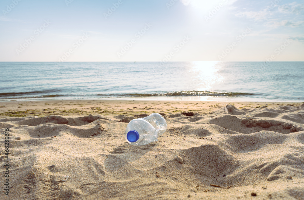 An empty, discarded plastic bottle on a sandy beach An empty, discarded plastic bottle on a sandy beach