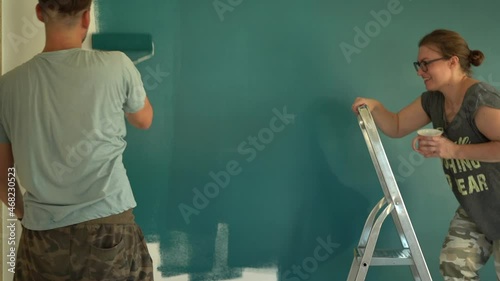 Wife and husband family doing home improvements. Wife gives husband a glass of water during renovation photo