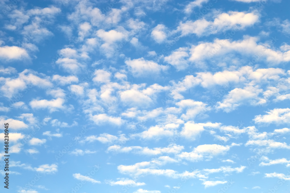 Naklejka premium White stratus clouds on summer blue sky - simple blurred background
