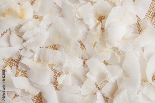 Coconut flakes or coconut chips on a rag background. Close up, selective focus.
