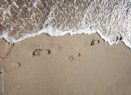 Fototapeta Naklejka Na Ścianę i Meble -  Foot print on sea wave and sand background.