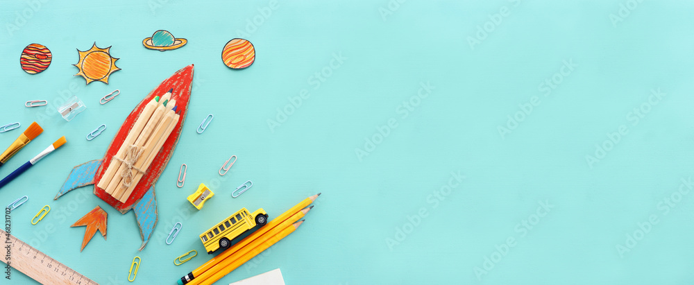 Fototapeta premium education. Back to school concept. rocket cut from paper and painted over blue wooden background. top view, flat lay