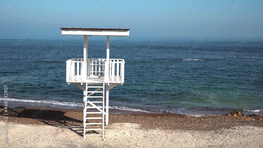 Old empty lifeguard tower on a sandy beach in sunny cloudless weather without people