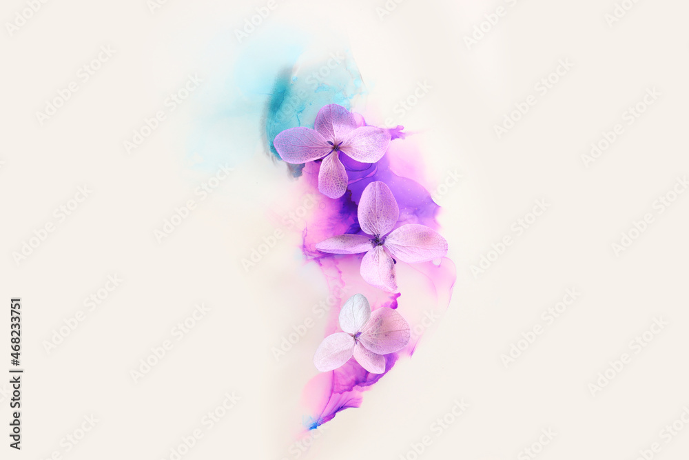 Obraz premium Creative image of pink and purple Hydrangea flowers on artistic ink background. Top view with copy space