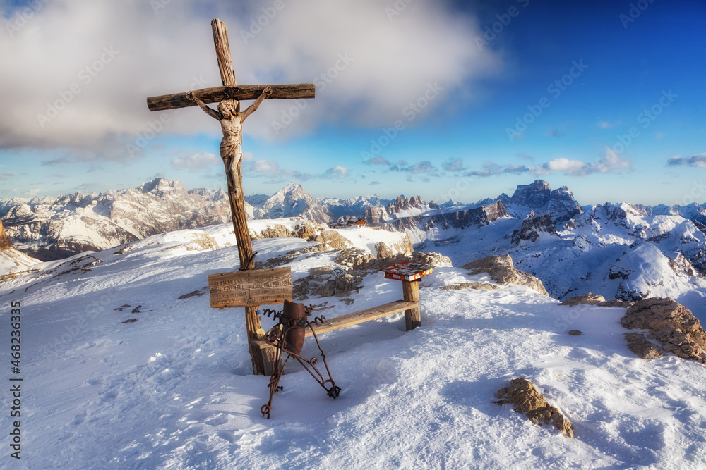 Cross on top of Mount Lagazuoi in the Dolomites near Cortina d'Ampezzo, Veneto, Italy. Winter Alpine landscape, Christmas postcard view.