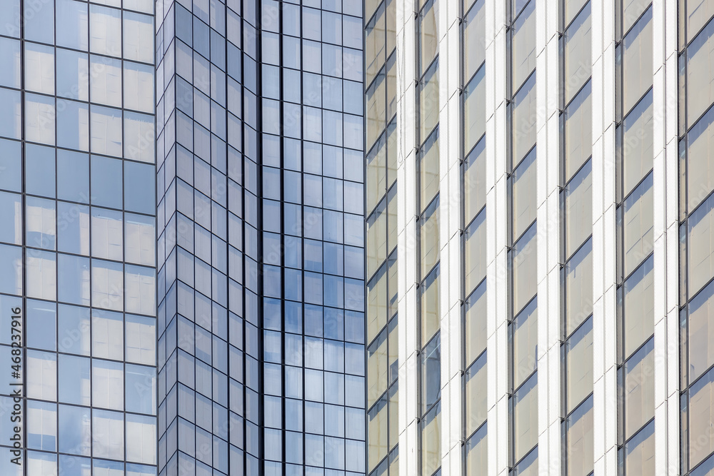 Glass facade of a new skyscraper. Endless rows of panoramic windows. Panoramic glazing of high-rise buildings. Lots of windows. Exterior of a modern city. Background, backdrop or texture Glass facade of a new skyscraper. Endless rows of panoramic windows. Panoramic glazing of high-rise buildings. Lots of windows. Exterior of a modern city. Background, backdrop or texture