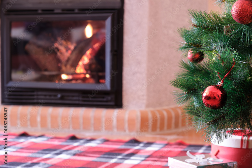 Christmas tree with red balls and fireplace in background Christmas tree with red balls and fireplace in background
