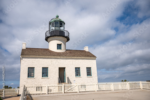 San Diego, California, USA - October 5, 2021: Cabrillo National Monument. Closeup of Old Point Loma Lighthouse front facade under heavy blue cloudscape.