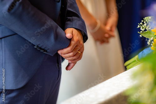 Standing male person hand in focus with wedding ring at wedding ceremony