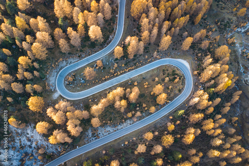 Spectacular aerial view of awinding and curvy road in the italian Dolomites during beautiful golden autumn photo