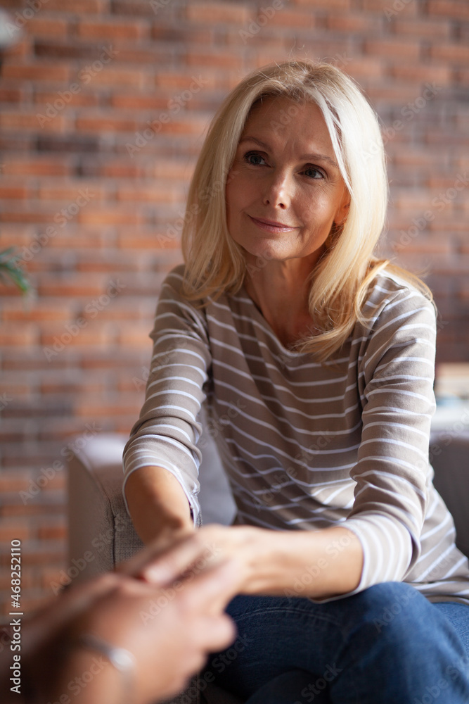 A mature woman holds the hands of her interlocutor. A moment of sympathy, closeness between older people. Forgiveness and Trust. A mature woman holds the hands of her interlocutor. A moment of sympathy, closeness between older people. Forgiveness and Trust.