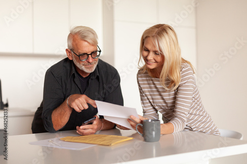 Mature husband and wife read the mailing notice. The couple was approved for a loan. Winning the lottery.