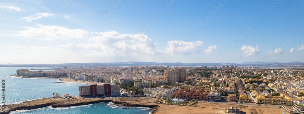 Drone point of view panoramic image of Torrevieja cityscape. Blue Mediterranean Sea and rocky seaside. Province of Alicante. Costa Blanca. Spain