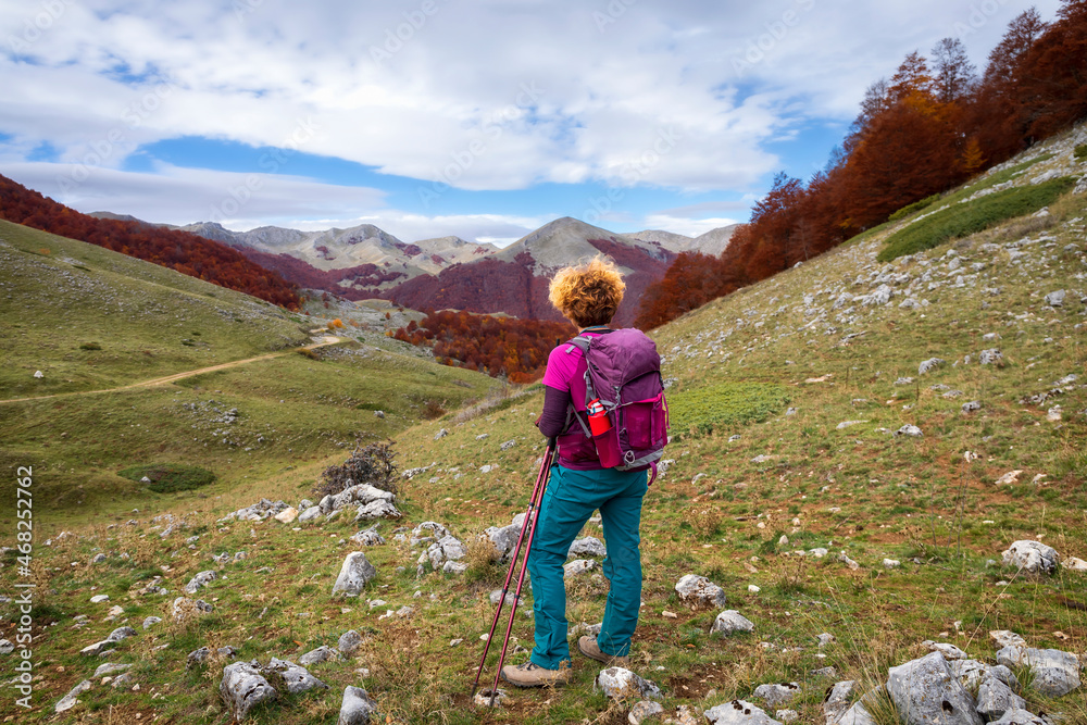 Hiker on the mountain trail explores the area during the autumn season.