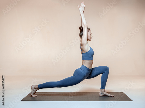 Yoga workout. Yogi girl perform crescent lunge pose or Ashta Chandrasana. Woman wellness and self-awareness concept photo