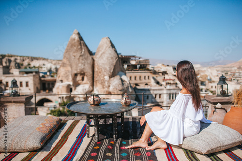 Happy young woman during sunrise watching hot air balloons in Cappadocia, Turkey © travnikovstudio