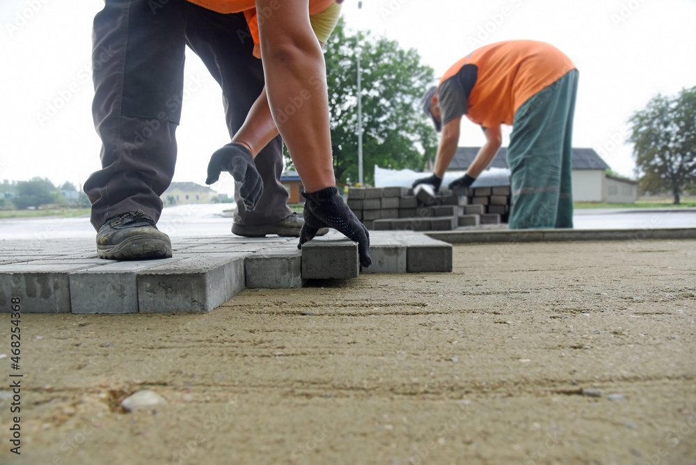 Builders lay concrete tiles, carry out road works. Builders lay concrete tiles, carry out road works.