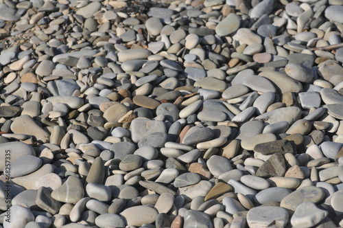Pebbles on the beach. Stones on the seashore. Background of stones