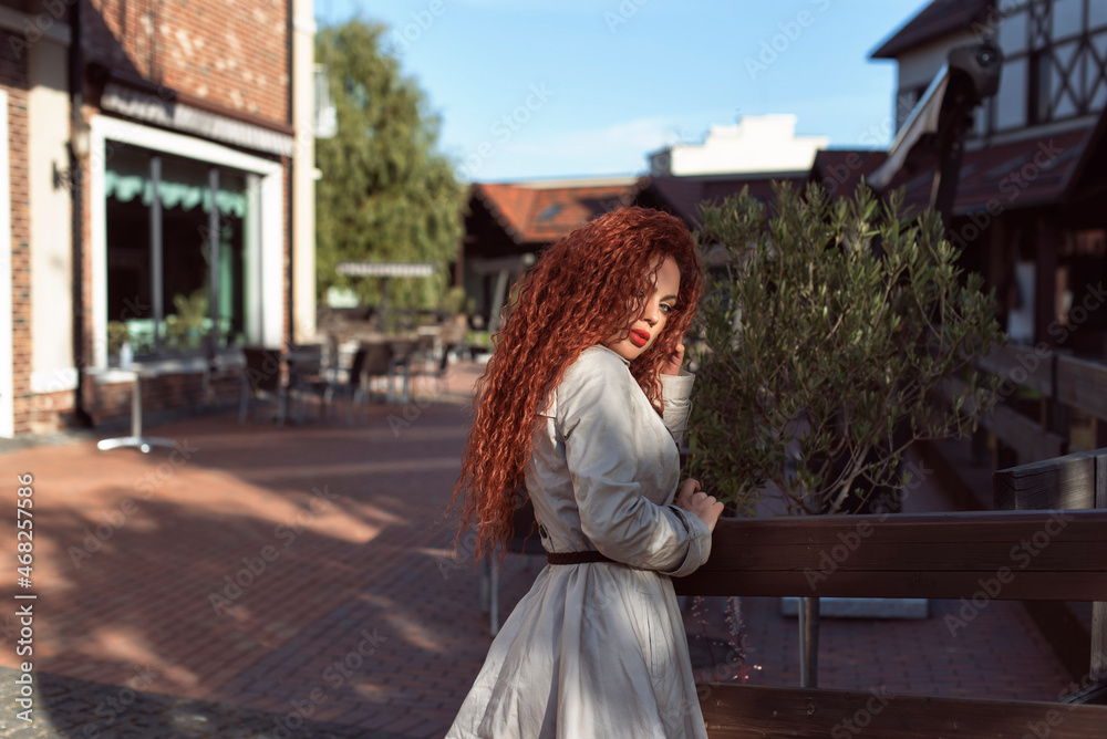 Fototapeta premium Redhead curly woman in the city