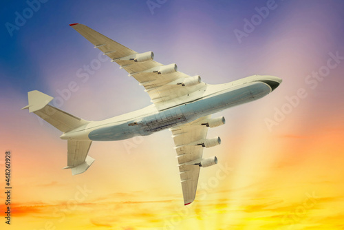Plane flight jet on sunset sky with sun and clouds