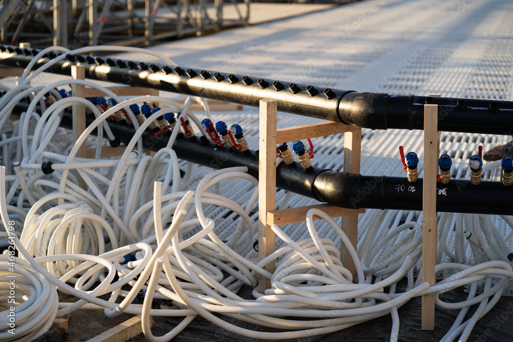 Cooling system for ice rink maintenance: plastic set of pipelines, tubes and hoses for low temperature and filling rink with water. Preparation for winter holidays outside activities in city