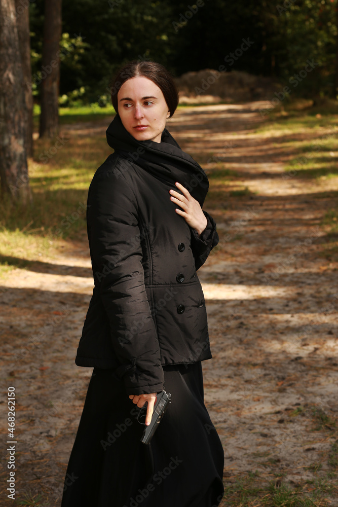 Brunette woman with a pistol in the forest Brunette woman with a pistol in the forest